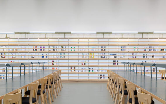 Harald Herlin Learning Centre library. Empty desks with bookshelves in the background.
