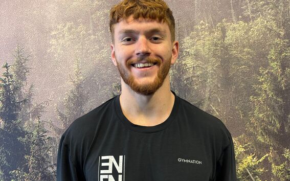 Henkilö sumennetuin kasvoin mustassa ENGN CrossFit -paidassa metsätaustaa vasten.