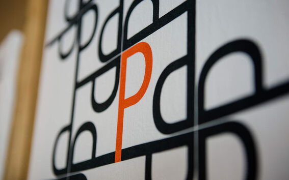 A grid of black letters 'd' with one orange letter 'P' in the centre on a white background.