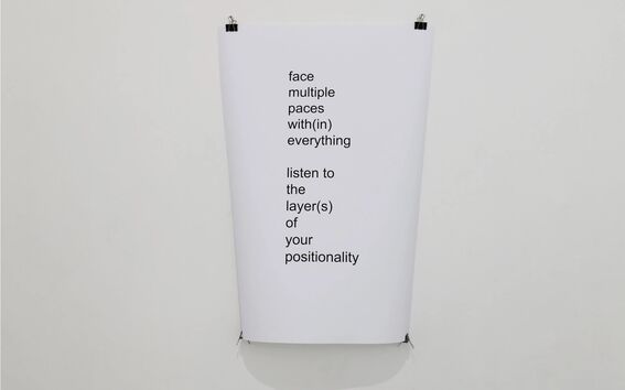 White poster with black text: 'face multiple paces with(in) everything; listen to the layer(s) of your positionality.'
