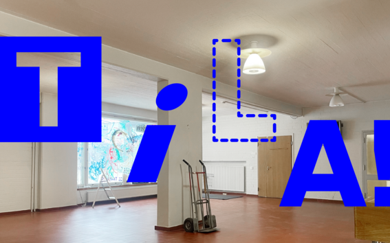 Tyhjä sisätila, punainen lattia, valkoiset seinät, nokkakärryt ja suuri sininen teksti ”TILA!”