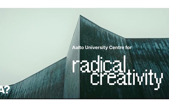 Angular teal building under grey sky with text: Aalto University Centre for radical creativity
