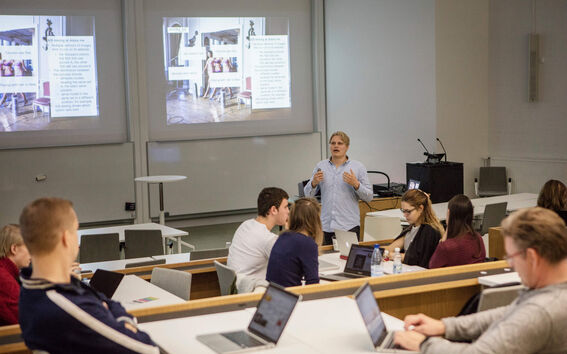 Photo of lecture with students participating with laptops