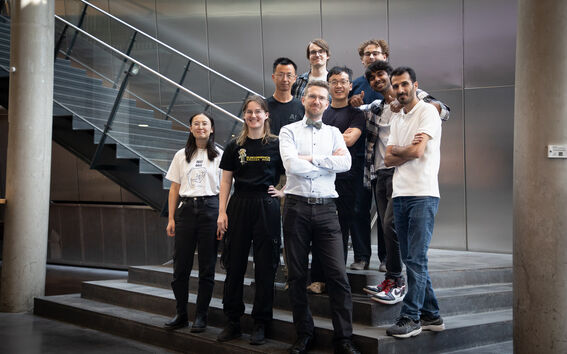 Professor and research group standing on staris 