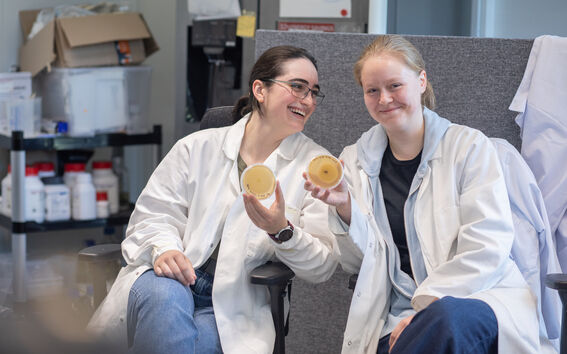 Two summer researchers holding Petri dishes 
