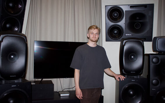 Sauli Norja stands among large loudspeakers in a studio.