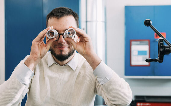 A man peeks through components as if using binoculars.