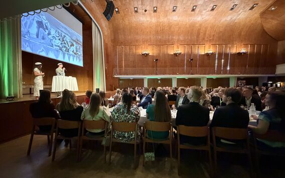 On the stage, KY Chair of the Board Vilma Paavola and alumni representative Tatu Lehtisyrjä, in the crowd class representatives sitting at the tables.