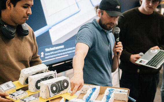 Nelihenkinen opiskelijatiimi esittelee karkeaa prototyyppiään.