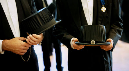 Two persons holding doctor's hats