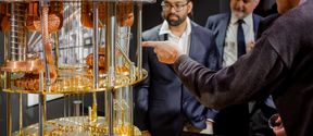 Three people look at a quantum computer