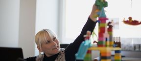 Pauliina Ilmonen rakentaa tornia lego-palikoista kuvattuna työhuoneessaan. Kuva: Heidi-Hanna Karhu.