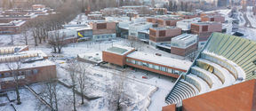Drone image of Otaniemi campus in early December, light covering of snow everywhere, with low sun shining