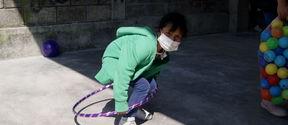 Care spaces- A play street in Mexico city, with a young girl playing with a hula hoop