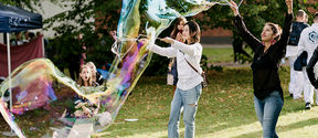 Students doing big soap bubbles in a party for semester start.