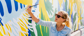 a woman painting a wall
