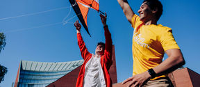 Two guys flying a kite on Otaniemi campus