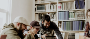 Students viewing a computer screen and laughing together 