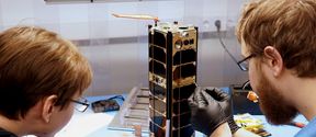 Engineers inspecting the Foresail-1 satellite in Aalto Satellite Laboratory.