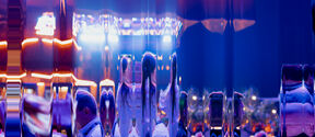 A reflective surface distorts the view of people dressed formally in a vibrant room with bright lights.