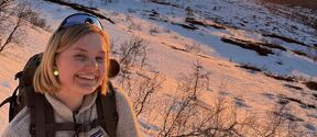 Alum Laura Suomalainen hiking on snowy mountains. 