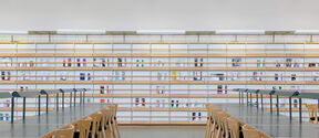 Harald Herlin Learning Centre library. Empty desks with bookshelves in the background.