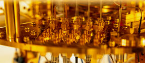 Close-up of a complex gold-coloured machine with various wires and connectors.