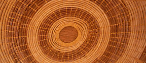 Close-up of a round woven basket in light brown, seen from above with concentric rings