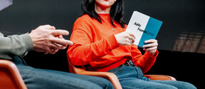 Tyttö, jolla on kädessään valkoinen ja sininen kortti, jossa lukee ”Aalto Founder School”
