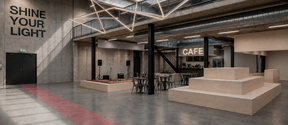 Spacious hall with a stage, tiered seating and a café
