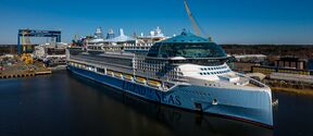 Suuri valkoinen risteilyalus Legend of the Seas telakalla kirkkaan taivaan alla