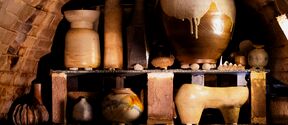 Shelves inside a Anagama kiln filled with assorted clay pots, vases and sculptures in earthy tones