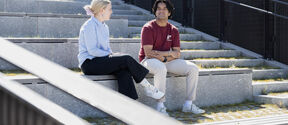 two students sitting outside