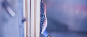 Blowtorch flame charring the side of stacked wooden boards in a metal test rig
