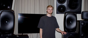 Sauli Norja stands among large loudspeakers in a studio.