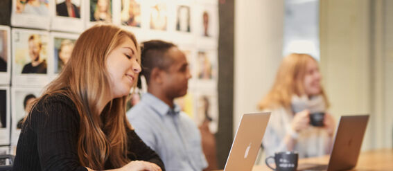 opiskelijat työskentelevät pöydän ääressä.