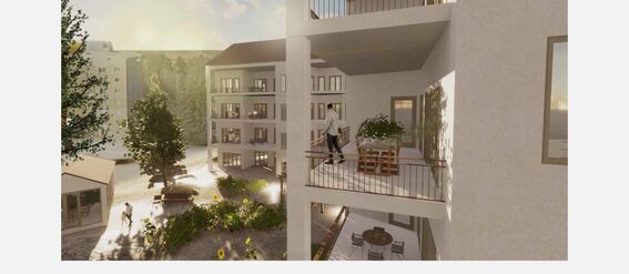 A modern apartment complex with balconies surrounded by greenery. A person stands on a balcony overlooking a lush courtyard.