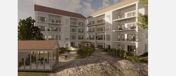 A modern four-storey building with large windows and balconies. A small pavilion is in the foreground surrounded by greenery.