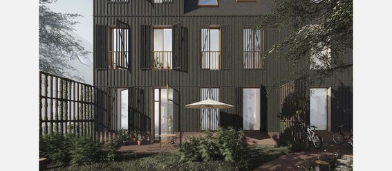 Modern dark grey building with large windows and a patio with greenery, bicycles, and a seating area.