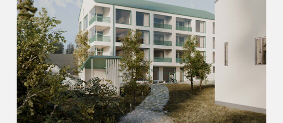 Modern four-storey building with green roof and balconies. Trees and a path leading to the entrance are in the foreground.