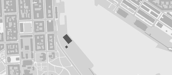 A grayscale map showing a city layout with buildings, streets, and a large open area near the waterfront.
