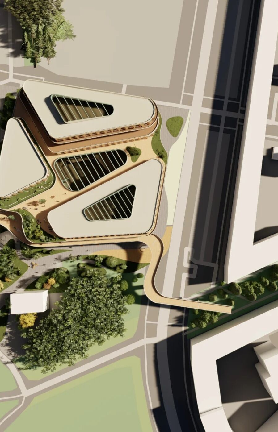 Aerial view of a modern building complex with triangular roofs, surrounded by roads and greenery.