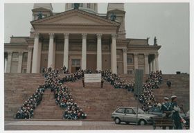 Opiskelijajoukko istuu Helsingin tuomiokirkon rappusilla muodostelmassa, josta syntyy kirjaimet KY 