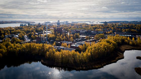 An autumnal aerial view of Aalto University campus from Laajalahti, autumn colours, yellow and orange, are prominent in the trees