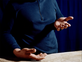 Looking down at his hands, a photo by Anne Golaz