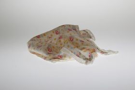 Käytetty ruusukuvioinen kangasnenäliina studiokuvassa