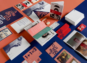 on a table a set of different booklets, books, postcards and a stationery kit