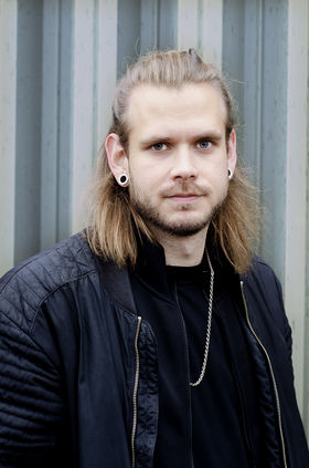 A portrait photograph of a man dressed in black