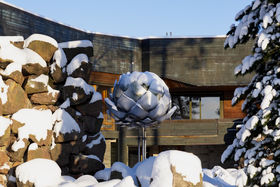 Dipoli and Pinecone in February snowy scene, light snow covering on buildings, rocks and tree branches