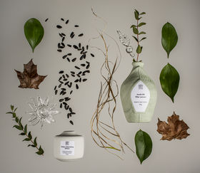 two ceramic pots with leaves and plants around them